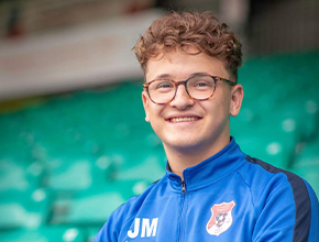 Student sitting in football stands